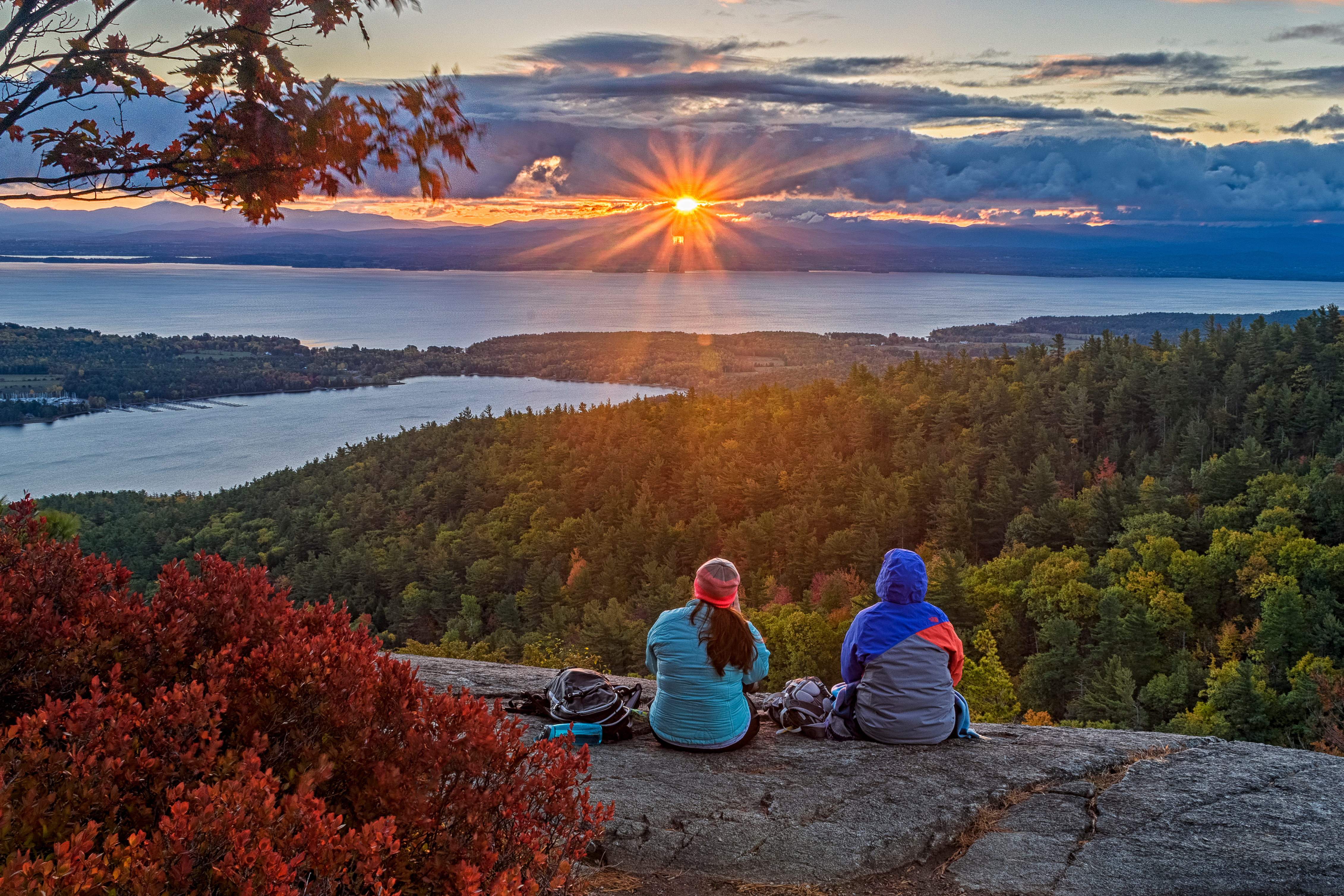 Hikers on a summit watching the sun rise.