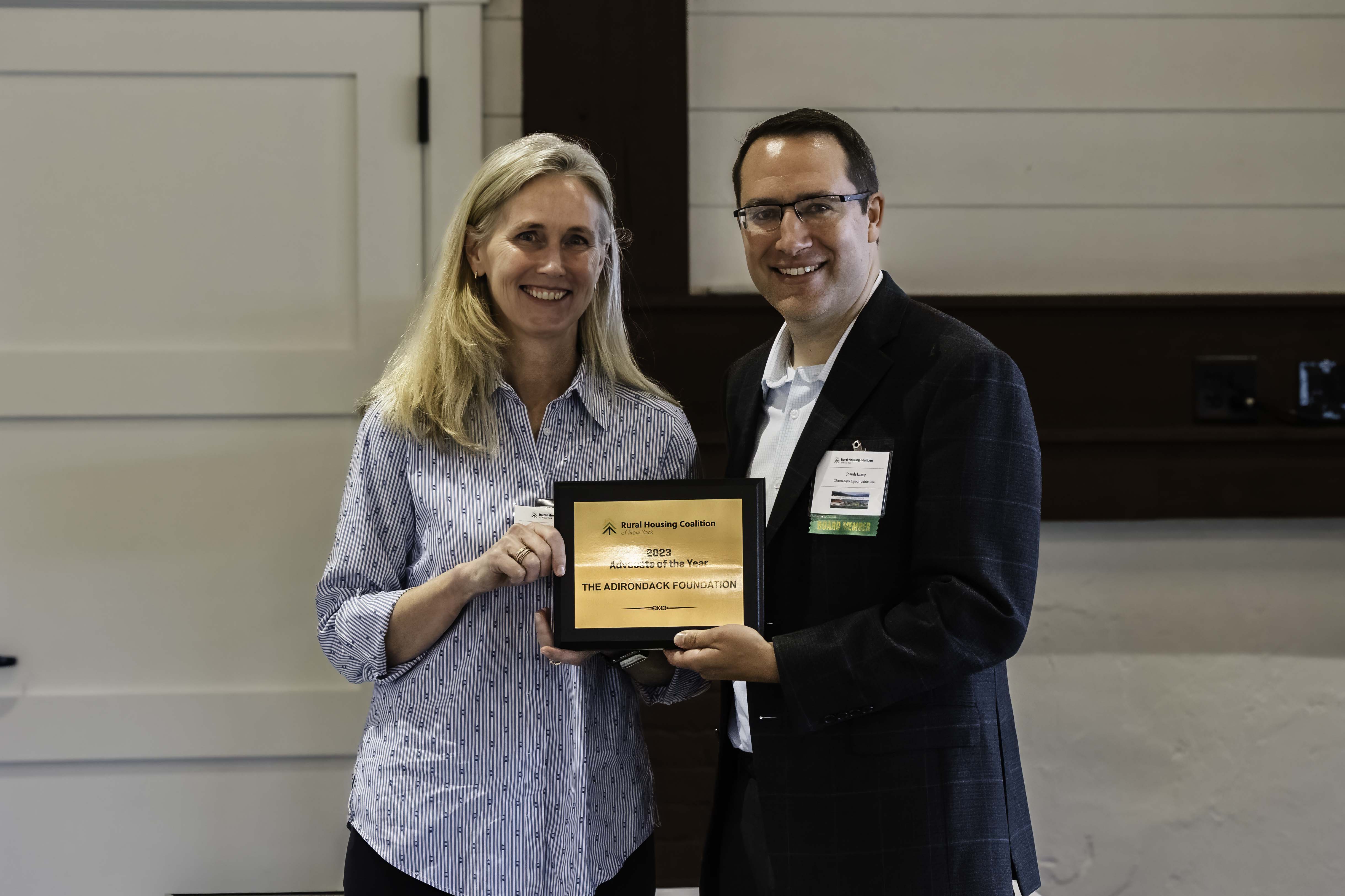 Josiah Lamp, chair of the Rural Housing Coalition (RHC), presents Adirondack Foundation Vice President for Community Impact Lori Bellingham with the 2023 Advocate of the Year at RHC's annual meeting in Lake George.
